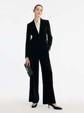 A lady wears a black velvet blazer.